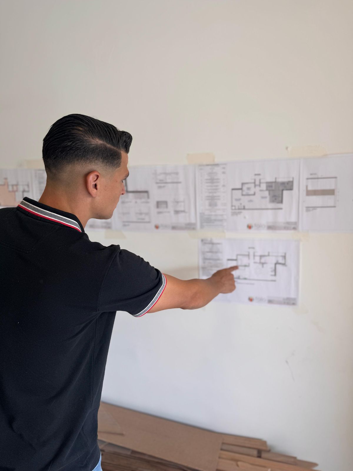 Técnico da Project Ar Condicionado apresentando projeto em planta na parede
